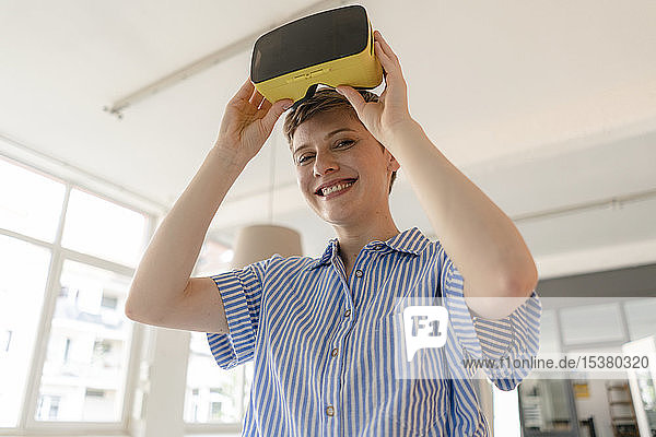 Portrait of smiling businesswoman with VR glasses in office
