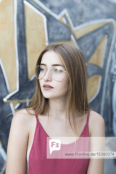 Porträt einer jungen Frau vor Graffiti