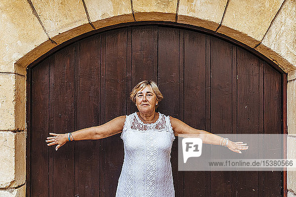 Porträt einer älteren Frau vor einer Holztür