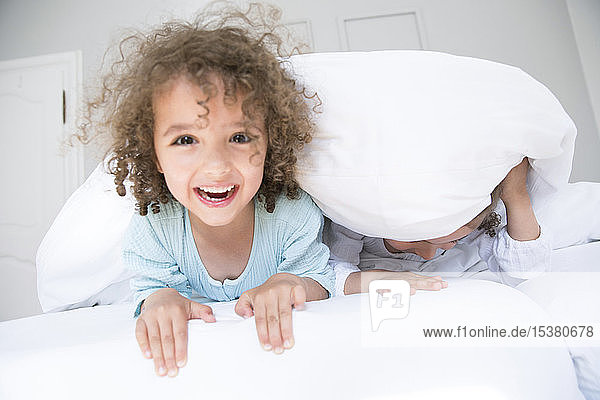 Porträt eines glücklichen Jungen mit seinem Bruder im Bett
