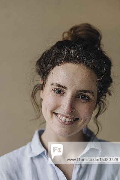 Porträt einer lächelnden jungen Frau mit Brötchen