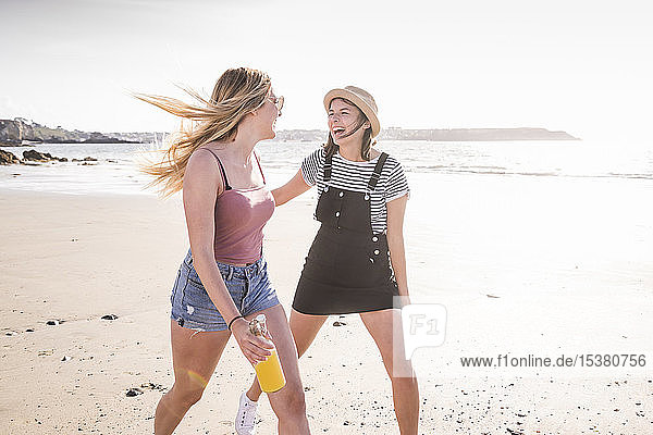 Zwei Freundinnen amüsieren sich  rennen und springen am Strand