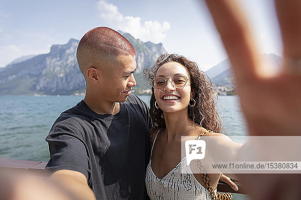 Young couple taking selfie in front of Lake Como  Lecco  Italy