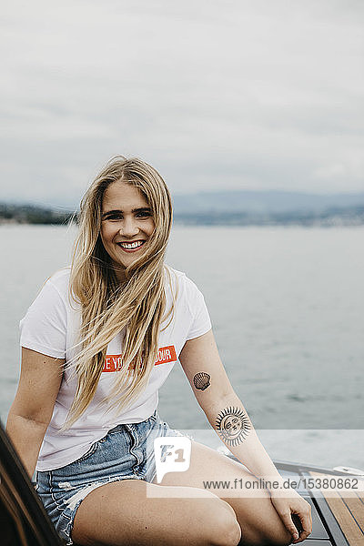 Porträt einer glücklichen jungen Frau bei einer Bootsfahrt auf einem See