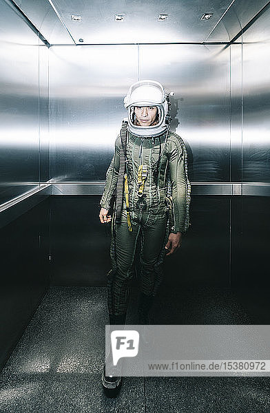 Mann posiert als Astronaut verkleidet in einem Aufzug