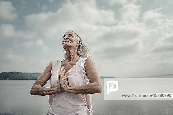 Meditation einer älteren Frau am Meer