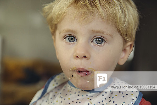Porträt eines blonden kleinen Jungen  der Kaviar und Ei isst