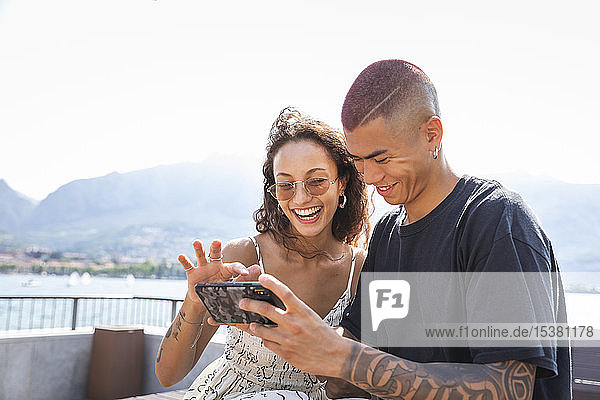 Glückliches junges Paar schaut auf Handy  Lecco  Italien