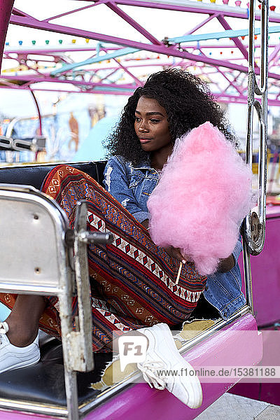 Portrait of young woman with pink candyfloss at fair