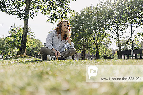 Redheaded woman sitting on grass verge