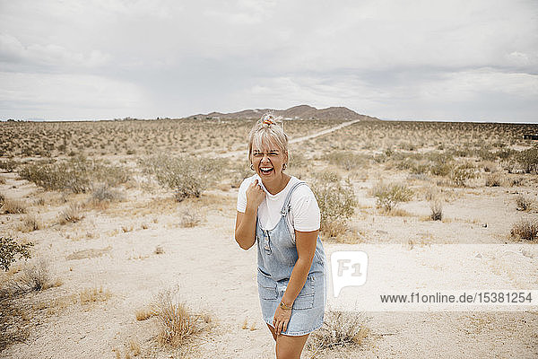 Portrait of laughing young woman in desert landscape  Joshua Tree National Park  California  USA