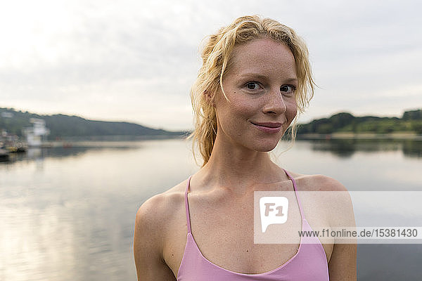 Porträt einer lächelnden jungen Frau an einem See
