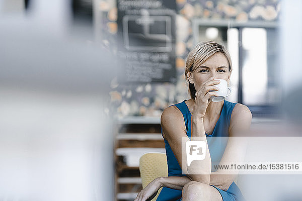 Frau trinkt Kaffee in einem Kaffeehaus