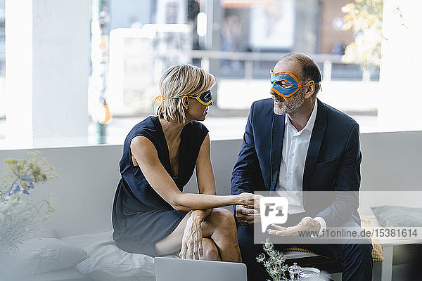 Geschäftsmann und -frau mit Superhelden-Masken  die versuchen  Lösungen zu finden