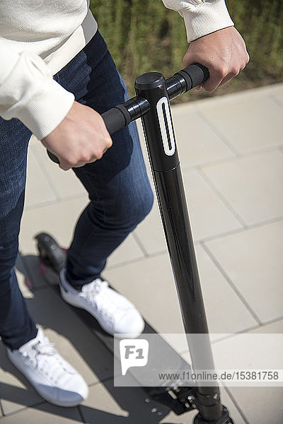 Close-up of man using e-scooter in the city