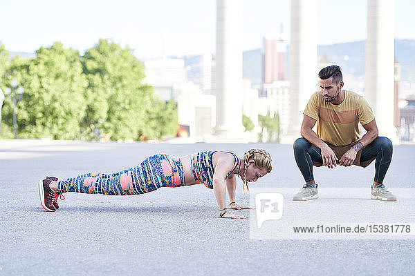 Fitnesstrainerin die mit jungen Frauen im Freien in der Stadt trainiert