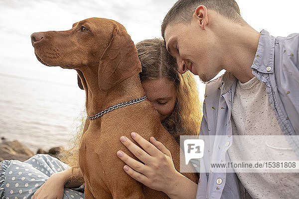 Junges Paar mit Hund am Strand