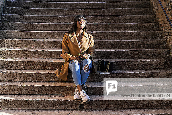 Weibliche Touristin sitzt auf einer Treppe im Freien