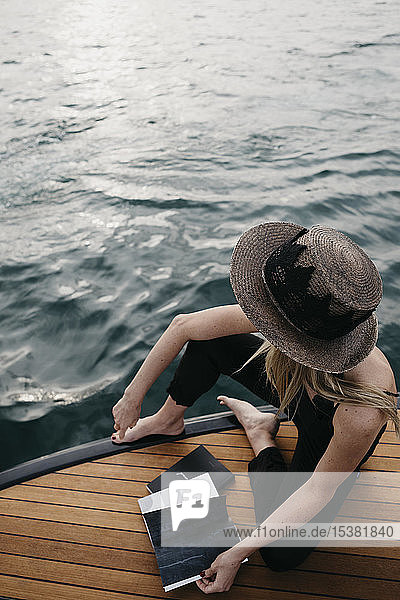 Frau mit einem Buch auf einem Boot