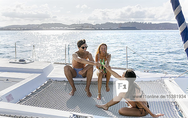 Drei junge Freunde genießen einen Sommertag auf einem Segelboot