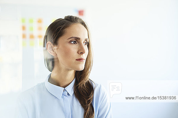 Portrait of young businesswoman looking away in office
