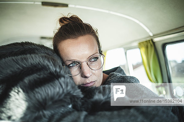 Woman lying on a blanket in a van