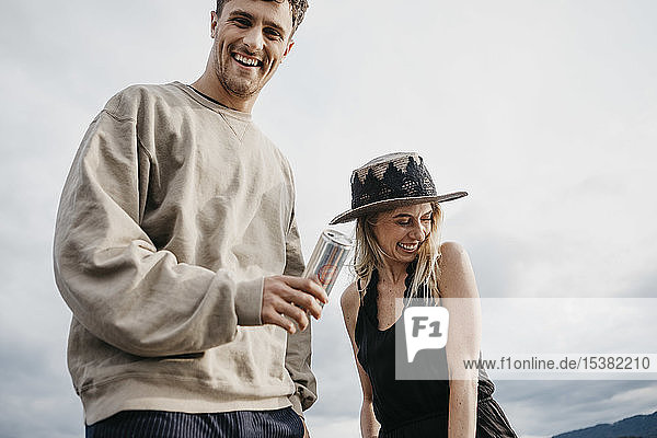 Happy young couple having a drink outdoors