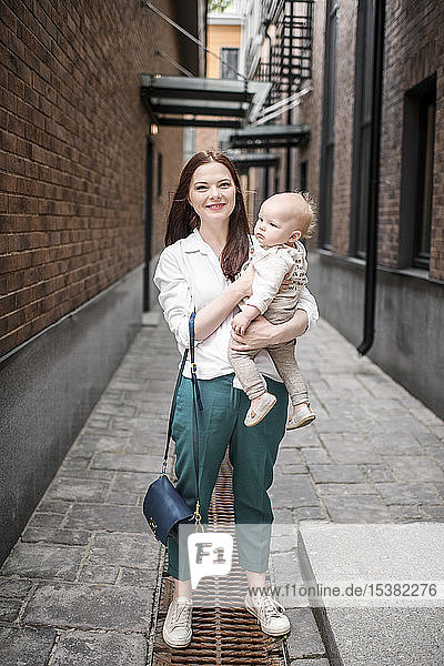 Mother holding her baby boy in an alley