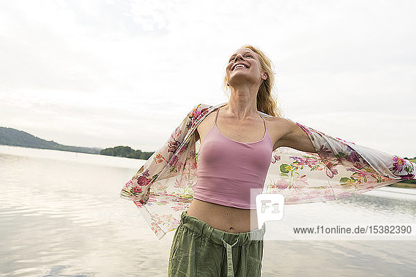 Glückliche junge Frau an einem See
