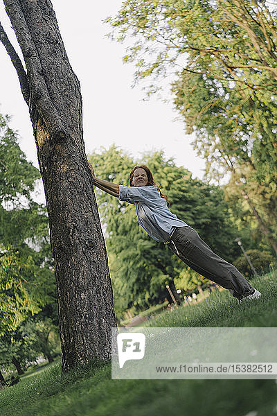 Frau in einem Park schiebt gekippten Baumstamm