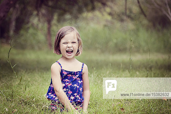 Porträt eines schreienden kleinen Mädchens auf einer Waldlichtung