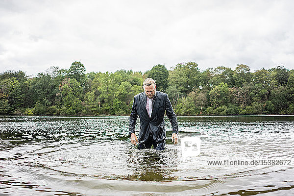 Wet businessman in a lake