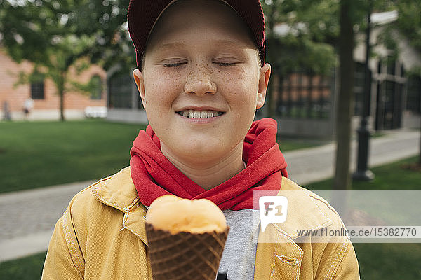 Boy with closed eyes  holding ice cream