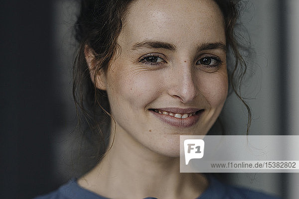 Porträt einer lächelnden jungen Frau mit braunen Augen