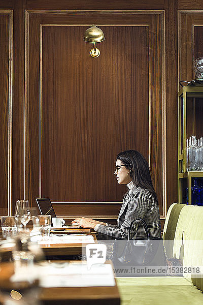 Geschäftsfrau mit Laptop in einem Restaurant