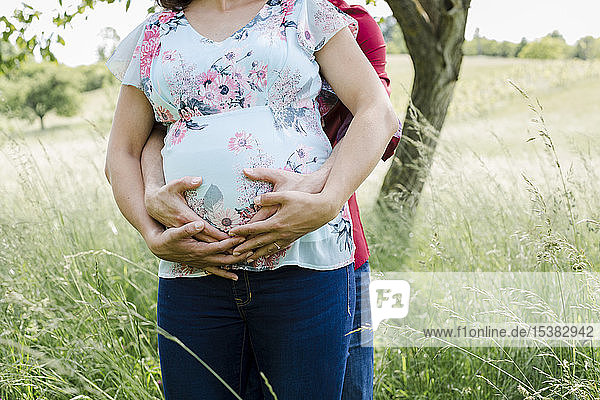 Schwangere Frau und Mann halten Babybauch