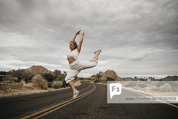 Frau springt auf Straße  Joshua-Tree-Nationalpark  Kalifornien  USA