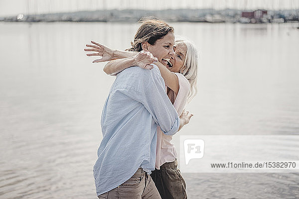 Mutter und Tochter verbringen einen Tag am Meer  lachen und umarmen sich