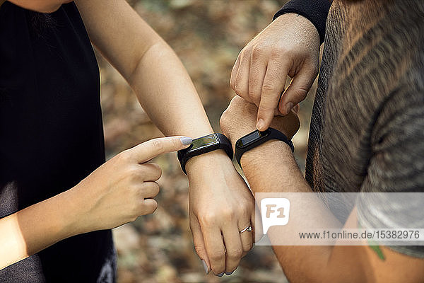 Nahaufnahme eines sportlichen Paares beim Prüfen von Smartwatches