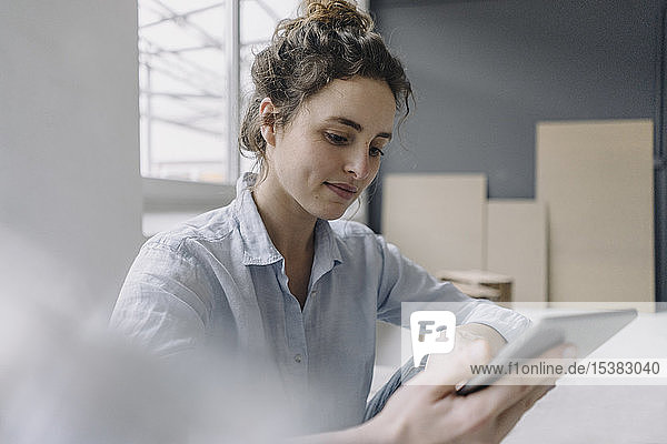 Porträt einer jungen Frau  die zu Hause ein digitales Tablet benutzt