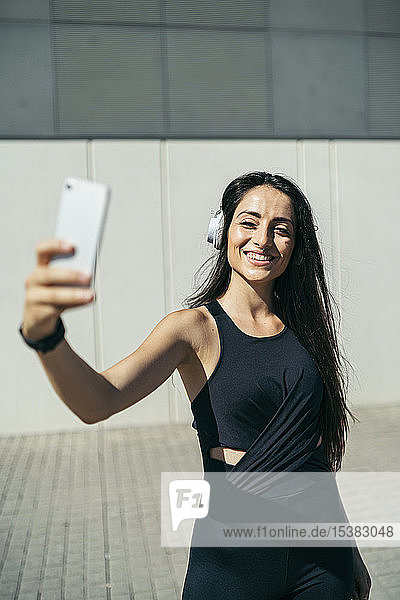 Young female jogger taking a selfie