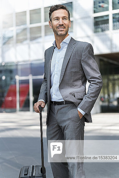 Portrait of smiling businessman with baggage
