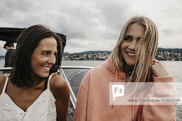 Glückliche Freundinnen bei einer Bootsfahrt auf einem See