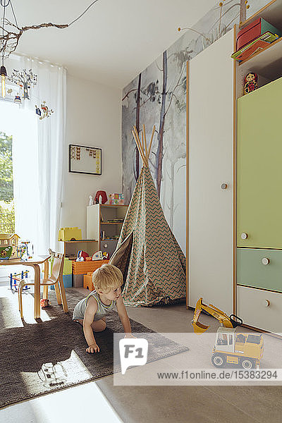 Kleiner Junge spielt in seinem Kinderzimmer