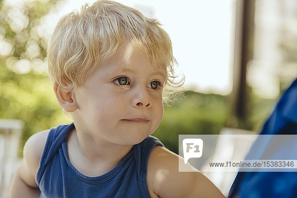 Porträt eines kleinen blonden Jungen im Sonnenlicht