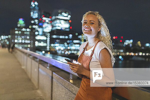 Junge Frau in London benutzt nachts ihr Smartphone