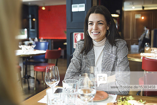 Porträt einer lächelnden Geschäftsfrau  die in einem Restaurant am Tisch sitzt