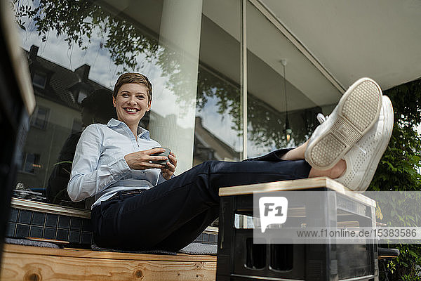 Porträt einer glücklichen Geschäftsfrau  die sich in einem Cafe entspannt