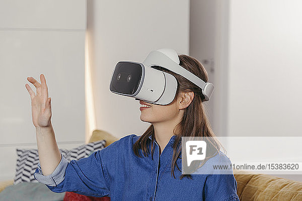Junge Frau mit VR-Brille zu Hause