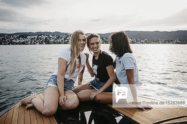 Happy female friends having fun on a boat trip on a lake